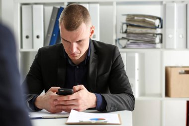 Yakışıklı düşünceli işadamı el cep telefonu bak