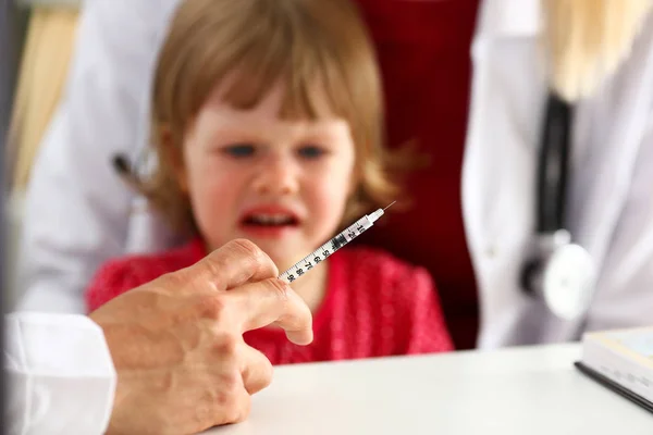 Маленька налякана дитина на прийомі лікаря робить інсулін знімок — стокове фото