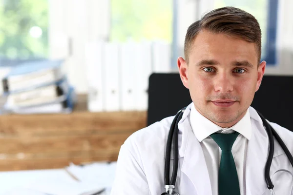 Guapo sonriente médico masculino de pie en la oficina —  Fotos de Stock