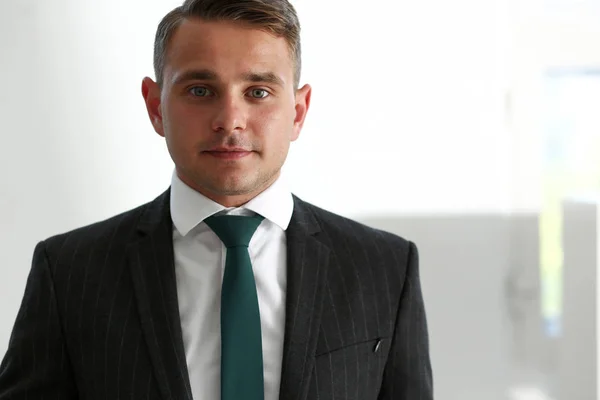 Przystojny człowiek uśmiechający się w garnitur i krawat stoją w biurze — Zdjęcie stockowe