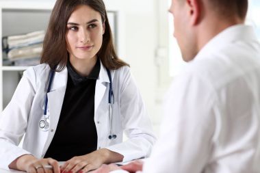 Kadın doktor gülümseyen güzel hasta ile konuşmak