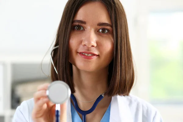 Bela sorridente médico feminino segurar na mão estetoscópio — Fotografia de Stock