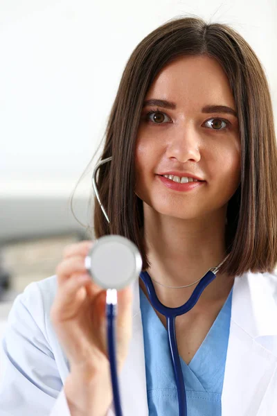 Schöne lächelnde Ärztin hält Stethoskop in der Hand — Stockfoto