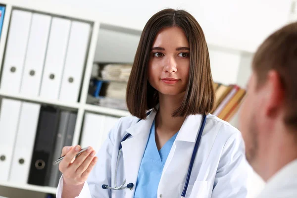 Concerned beautiful doctor discuss problem with sad patient