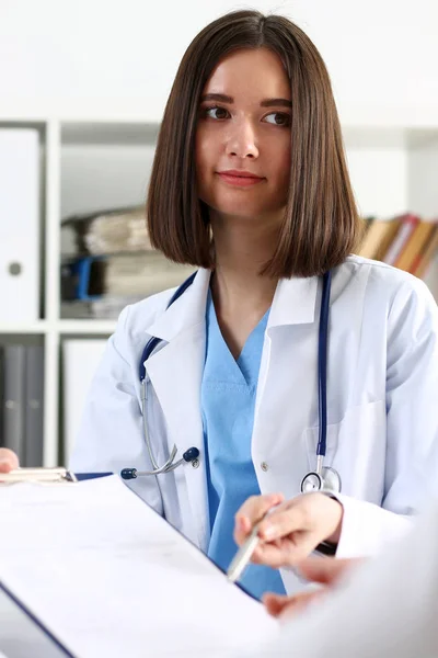 Schöner Arzt hält silbernen Stift und Block in der Hand — Stockfoto