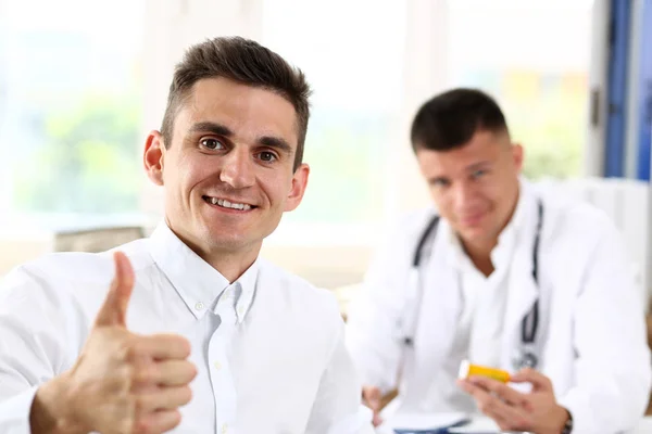 Hombre mostrando signo OK con el pulgar hacia arriba en el retrato del consultorio médico —  Fotos de Stock