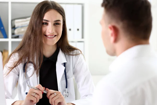 Schöne lächelnde Ärztin hält silbernen Stift — Stockfoto
