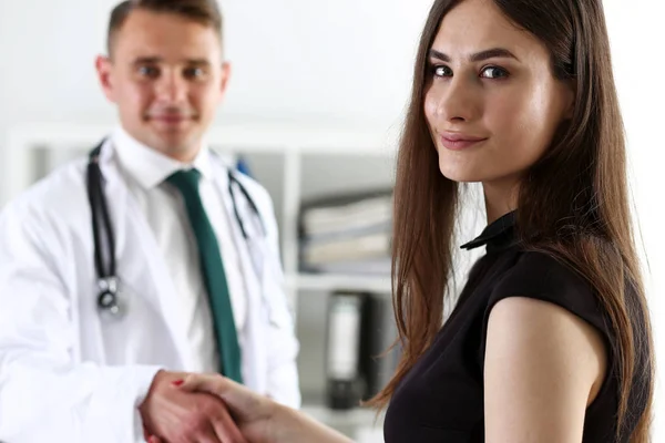 Handsome male doctor shake hand as hello with patient