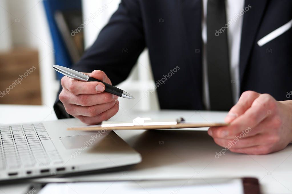 Hand of businessman in suit signing document