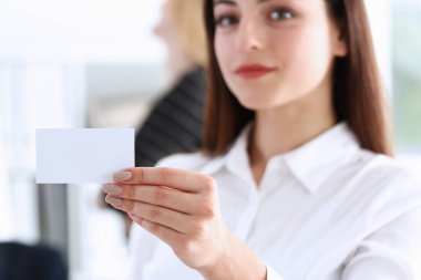 El kartvizit ambarda takım elbise içinde iş kadını gülümseyen