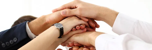 Group of people in suits crossed hands in pile