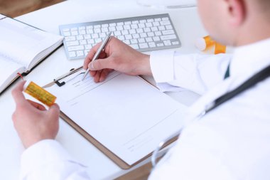 Erkek doktor el hapları kavanozunu tutuyor.