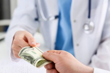 Kadın doktor yüz dolarlık banknot tutun