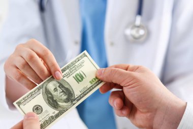 Kadın doktor yüz dolarlık banknot tutun