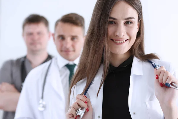 Gruppo di medici in posa fiero in fila e guardando in macchina fotografica — Foto Stock