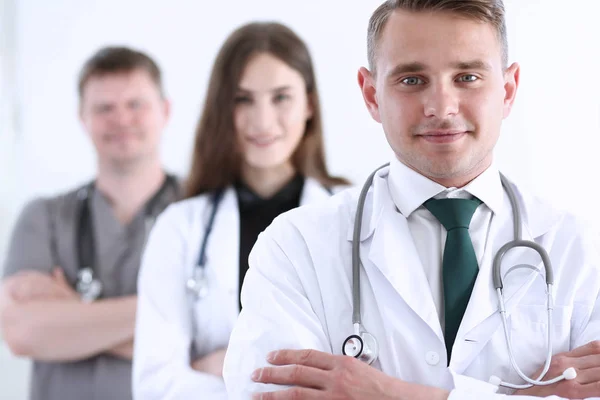 Grupo de médicos posando orgullosamente en fila y mirando a la cámara —  Fotos de Stock