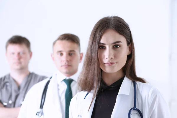 Grupp av sjukvårdare stolt poserar i rad och tittar i kameran — Stockfoto