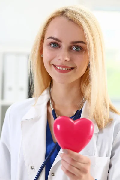 Kadın tıp doktor eller kırmızı oyuncak kalbinde tutun — Stok fotoğraf