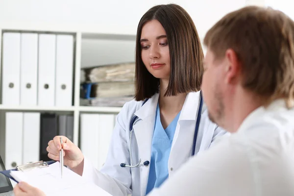 Ärztin hält silbernen Stift in der Hand und zeigt Block — Stockfoto