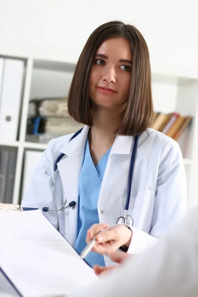 Hermoso médico en la mano pluma de plata y mostrar almohadilla — Foto de Stock