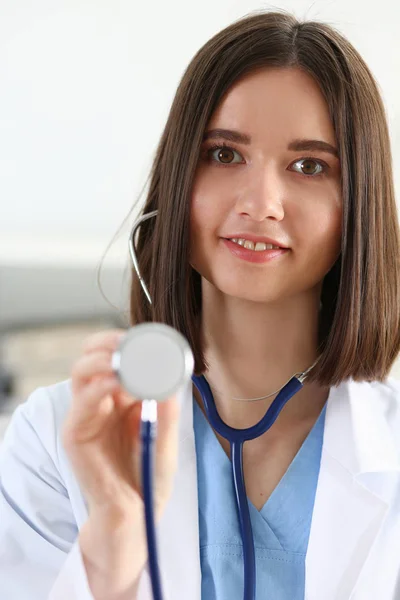 Bela sorridente médico feminino segurar na mão estetoscópio — Fotografia de Stock