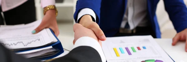 Man in suit shake hand as hello in office closeup