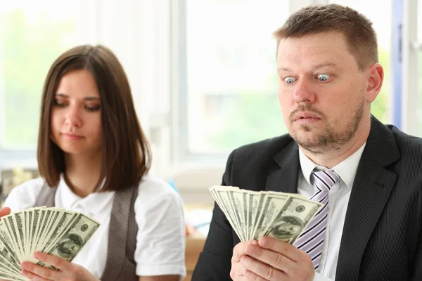 Un uomo e una donna godono di denaro leggero sotto forma di frode — Foto Stock