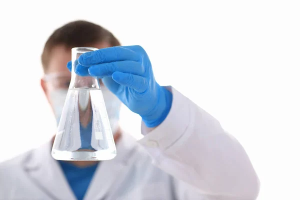 Ένα αρσενικό χημικός κατέχει δοκιμαστικό σωλήνα από γυαλί με το χέρι ξεχειλίζει ένα υγρό — Φωτογραφία Αρχείου
