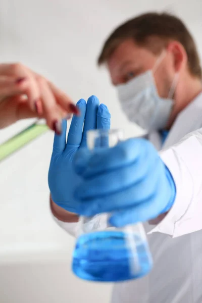 Un chimiste masculin tient un tube à essai de verre dans sa main déborde un liquide — Photo