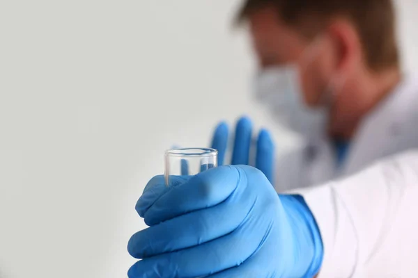 Химик держит в руке фляжку с голубой жидкостью — стоковое фото