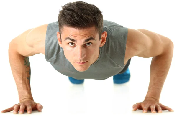 Fitness hombre retorciendo desde el suelo aislado en blanco — Foto de Stock