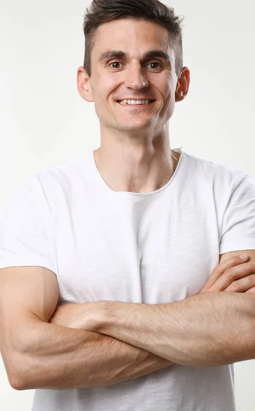 Hombre de fitness retrato lindo en una camiseta blanca sobre un fondo gris —  Fotos de Stock