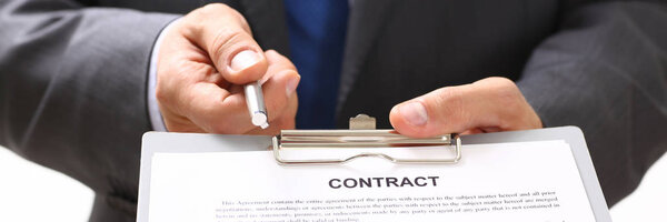 Красивый человек в костюме предлагает форму контракта на планшете
