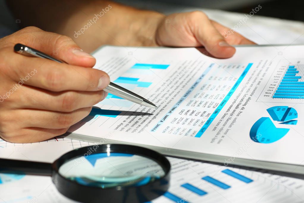 Financial statistics documents on clipboard pad at office table closeup