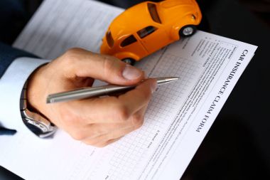 Masanın üzerinde yatan sigorta formu doldurma takım elbiseli erkek kol