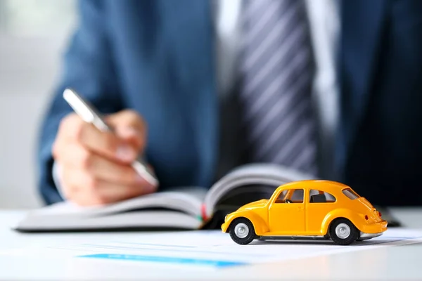 Coche de juguete amarillo irreconocible en la venta de documentos — Foto de Stock