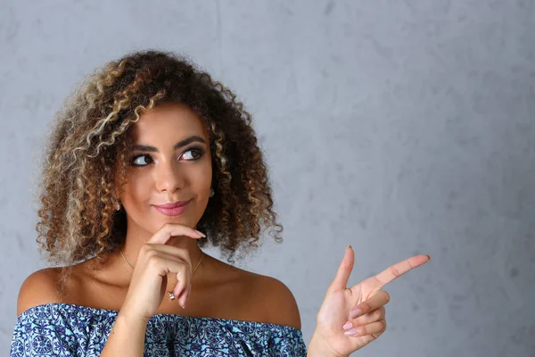 Gri bir arka plan üzerinde siyah bir kadın Puan bir parmak havada girmek için yazabilirsiniz bir yazıt