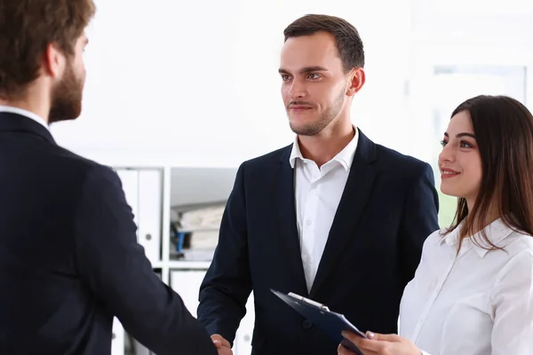 Uomo sorridente in tuta stringere la mano come ciao in ufficio — Foto Stock