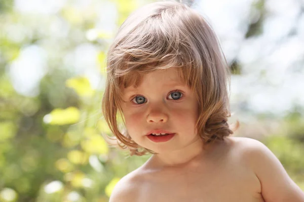 Felice bambino sorridente su uno sfondo naturale passeggiando nel parco — Foto Stock