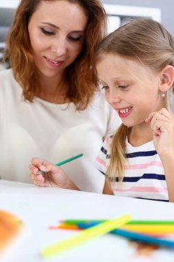 Sarışın küçük kız gülümseyerek kol kurşun kalemle çizim tutun