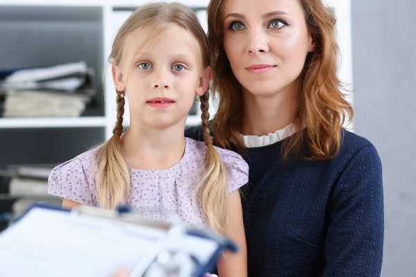 Küçük çocuk ile anne çocuk doktoru resepsiyonda