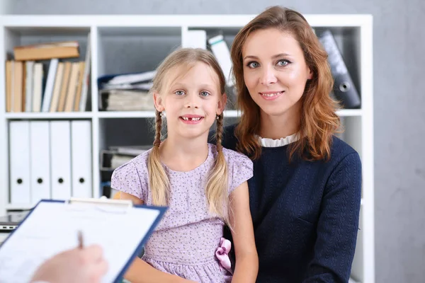 Küçük çocuk ile anne çocuk doktoru resepsiyonda