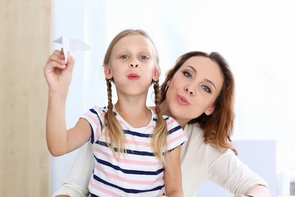 Blondes lächelndes kleines Mädchen bastelt Papierflieger — Stockfoto