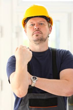 Sarı kask poz içinde gülümseyen komik işçi