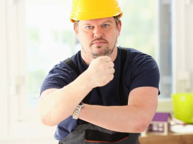 Sarı kask poz içinde gülümseyen komik işçi