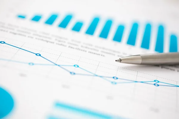 Estatísticas financeiras documentos caneta bola infográficos na mesa de escritório — Fotografia de Stock