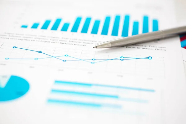 Estatísticas financeiras documentos caneta bola infográficos na mesa de escritório — Fotografia de Stock