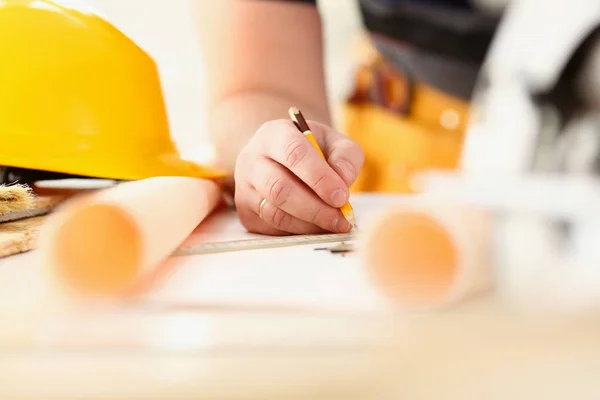 Arms of worker making structure plan on scaled paper — Stock Photo, Image