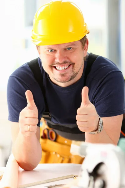 Lächelnder Arbeiter mit gelbem Helm zeigt Schild — Stockfoto