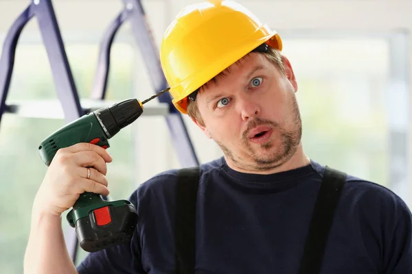 Trabalhador idiota usando retrato de broca elétrica — Fotografia de Stock